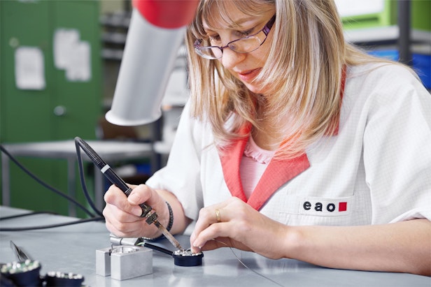Fachwissen Produktion – Techniker beim Löten elektronischer Bauteile an einem Arbeitsplatz in einer Fertigungsanlage. (EAO_CO_01_00058)